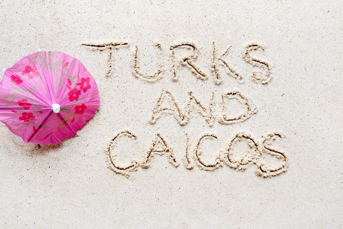 Handwriting words 'Turks and caicos' on sand